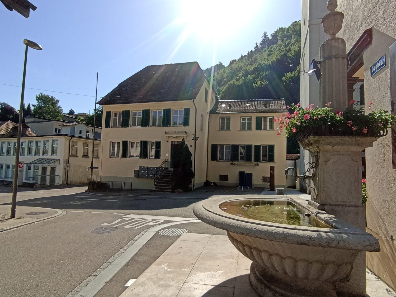Buildings with balconies and stairs, streetlight, fountain, road