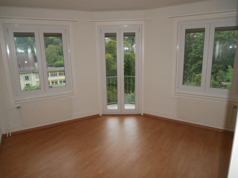 empty room, wooden floor, white walls, three windows, two radiators, balcony
