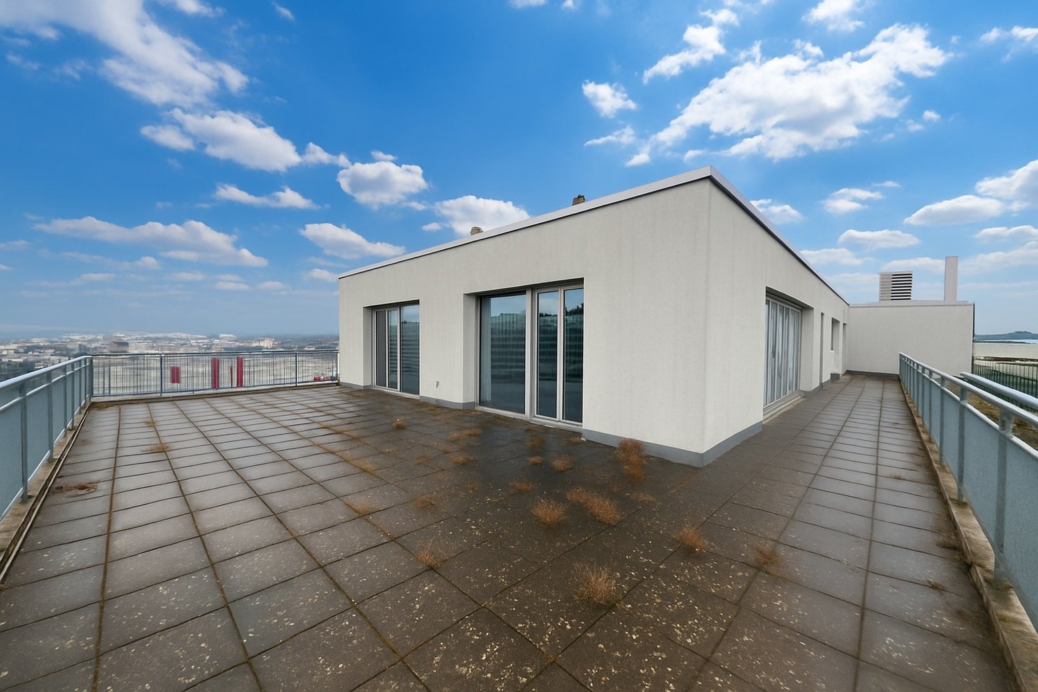 roof terrace, large windows, railings, rooftop view, buildings in the distance
