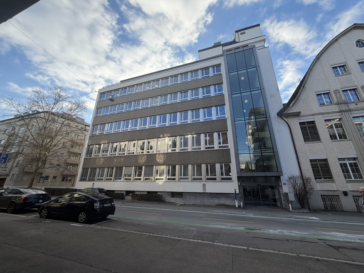 modern office building with glass windows, glass entrance, 4 parking spaces