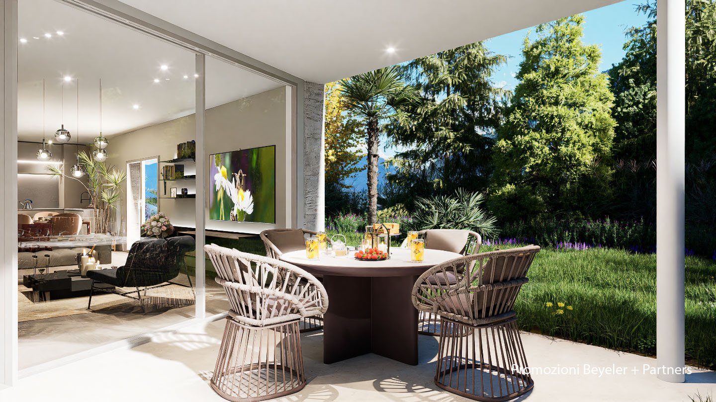 A patio area with a table and chairs, a glass wall, and an open view to a garden