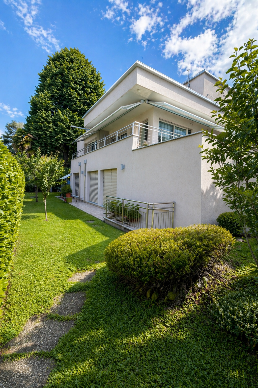 2 story house, white exterior, balcony, garage, garden, trees