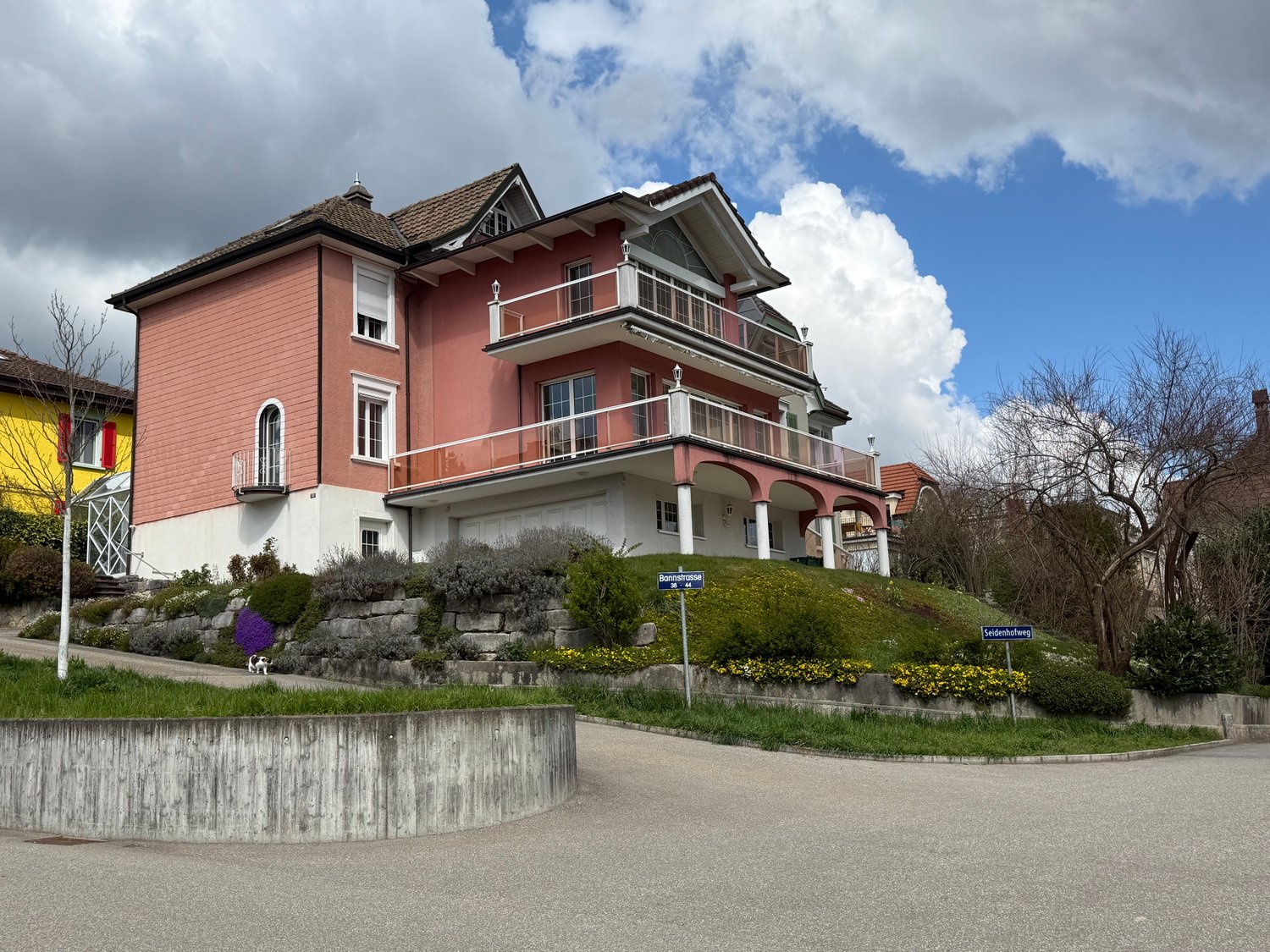 3 story house, pink and white exterior, balconies, garage, garden, street view