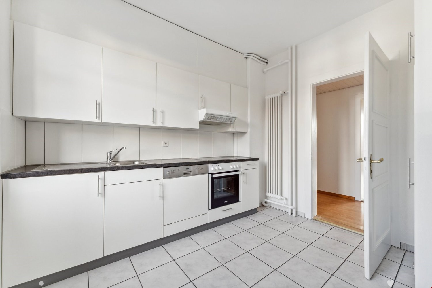 modern kitchen with white cabinets, tiled floor, stainless steel sink, dishwasher, oven, and a faucet