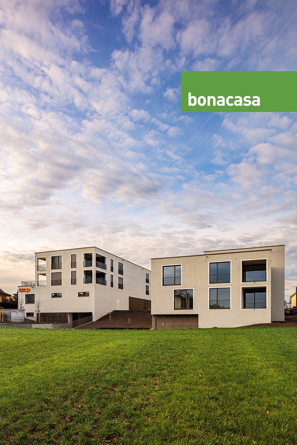 2 modern apartment buildings with balconies, multiple glass windows, elevated entrance