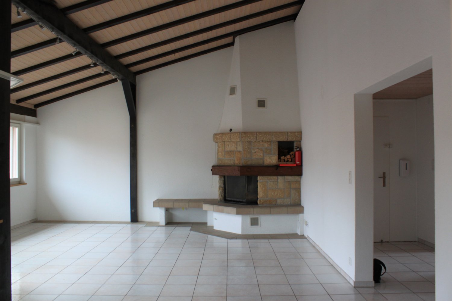 tiled floor, fireplace, white walls, ceiling lights, window