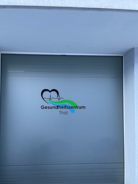 A gray entrance with a logo and the words 'Gesundheitszentrum Thal' on it.
