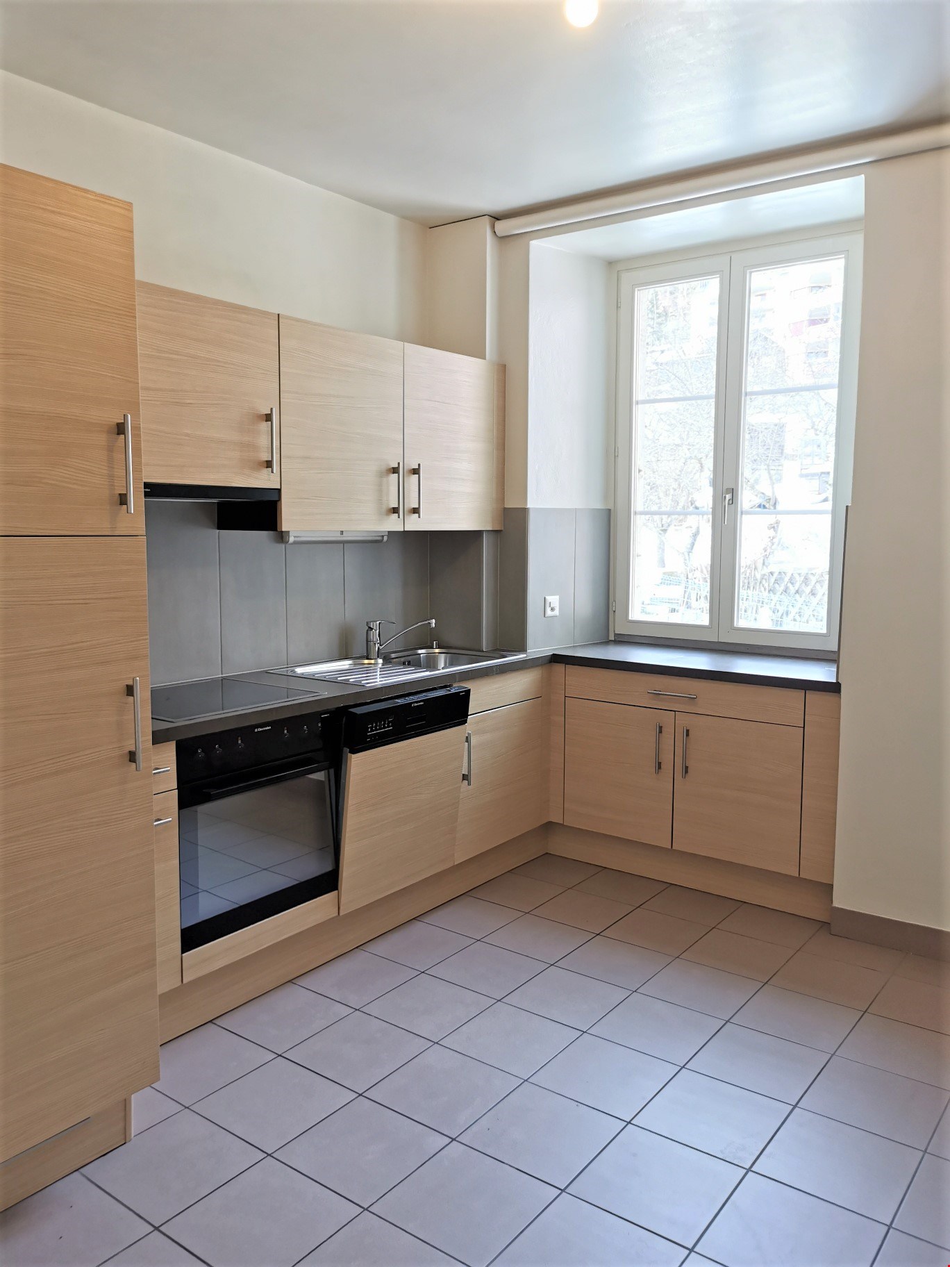 modern kitchen, tiled floor, wooden cabinets, stainless steel appliances, double sink, window