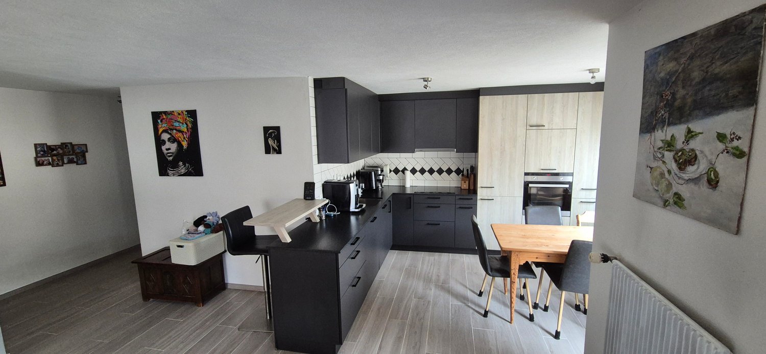 kitchen, black cabinets, wooden countertops, black chairs, wooden table, radiator, painting, black coffee machine