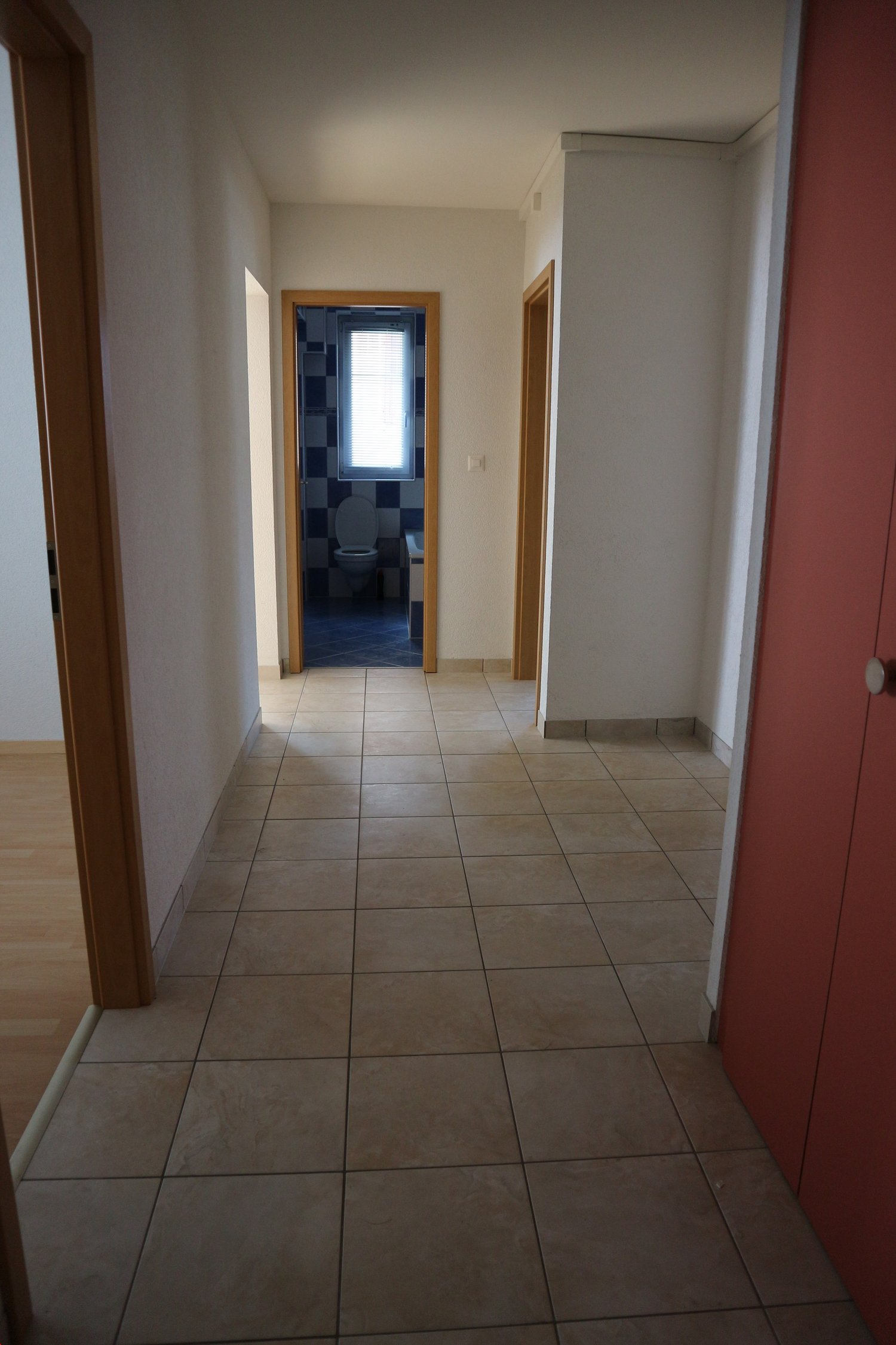 empty hallway, tiled floor, bathroom on the right