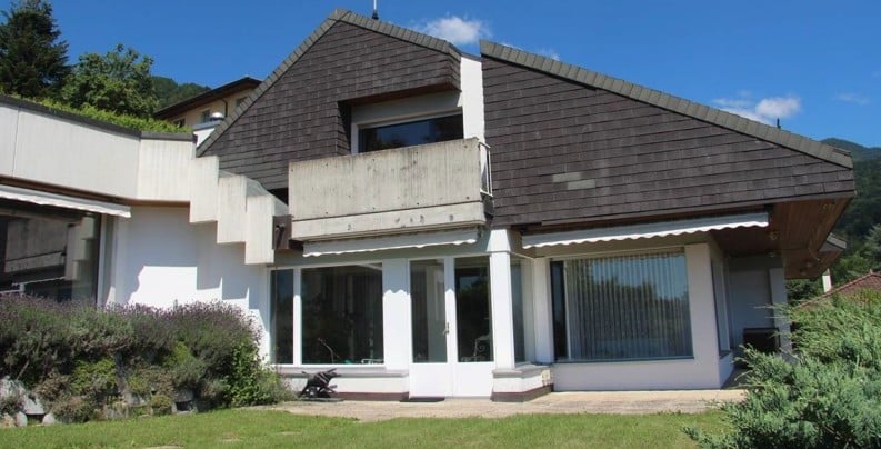 Modern white house, brown roof, terrace, garden, glass windows, shrubs