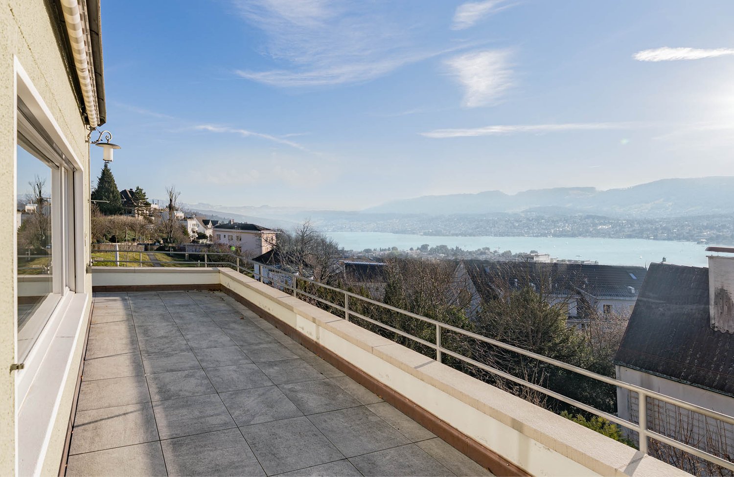 terrace with a tiled floor, steel railings, and a stunning lake and mountain view