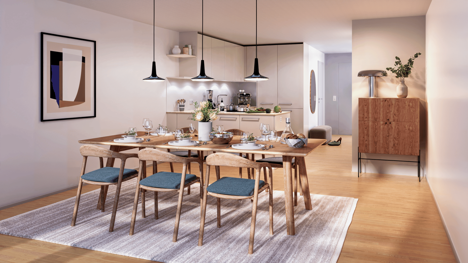Dining room with wooden table, chairs, and a rug. There is a kitchen in the background with a coffee machine, blender, and a vase with flowers.