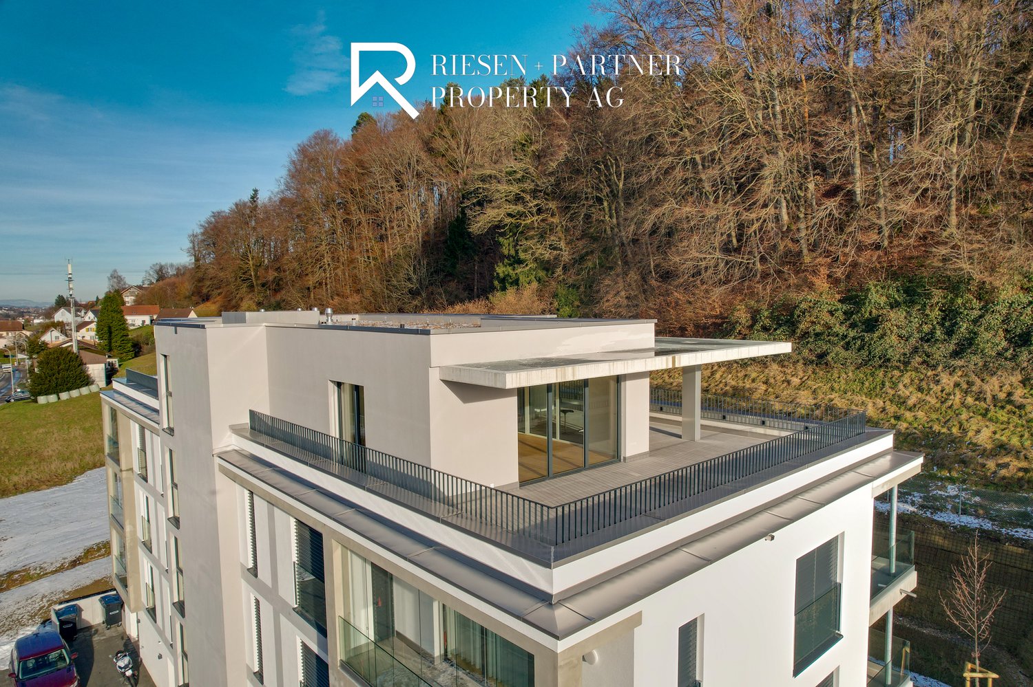 Two-story building with terrace on the second floor, glass windows, modern design, white exterior, trees, view of the hills