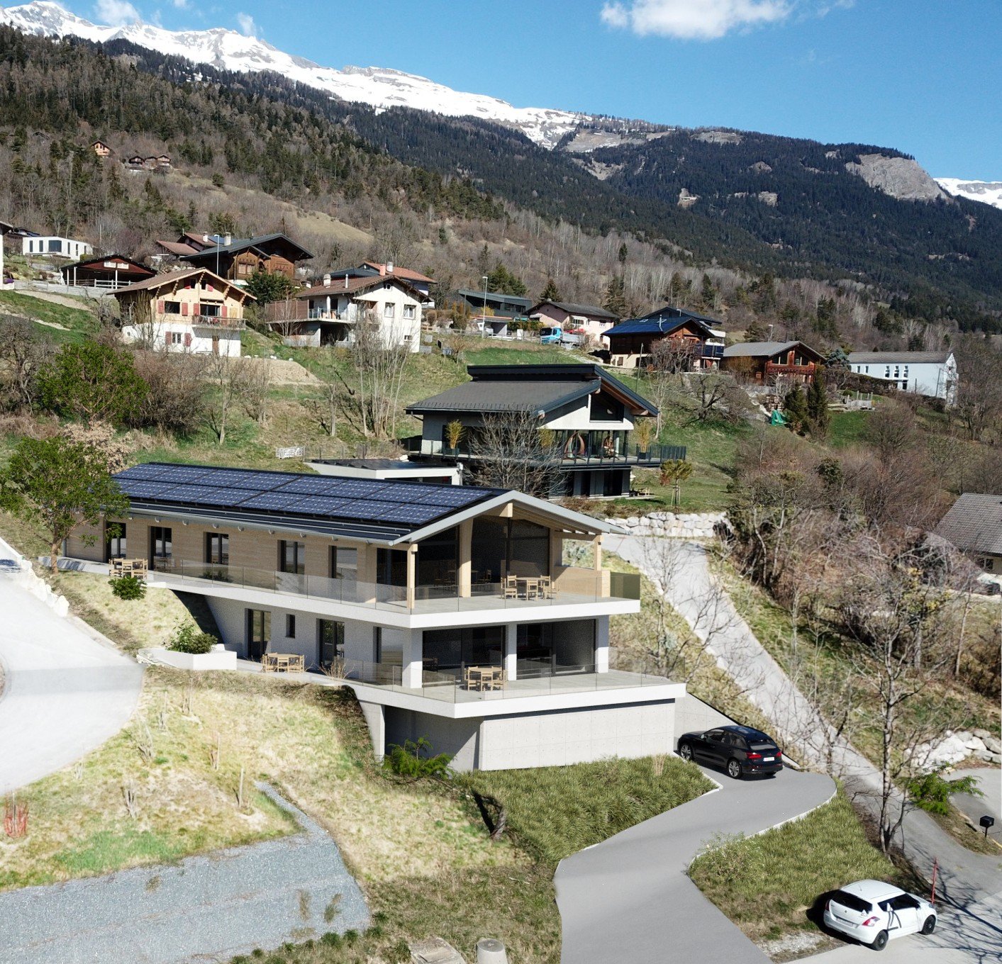 Modern house with solar panels, glass balconies, surrounded by other houses, mountainous area, driveway, cars parked