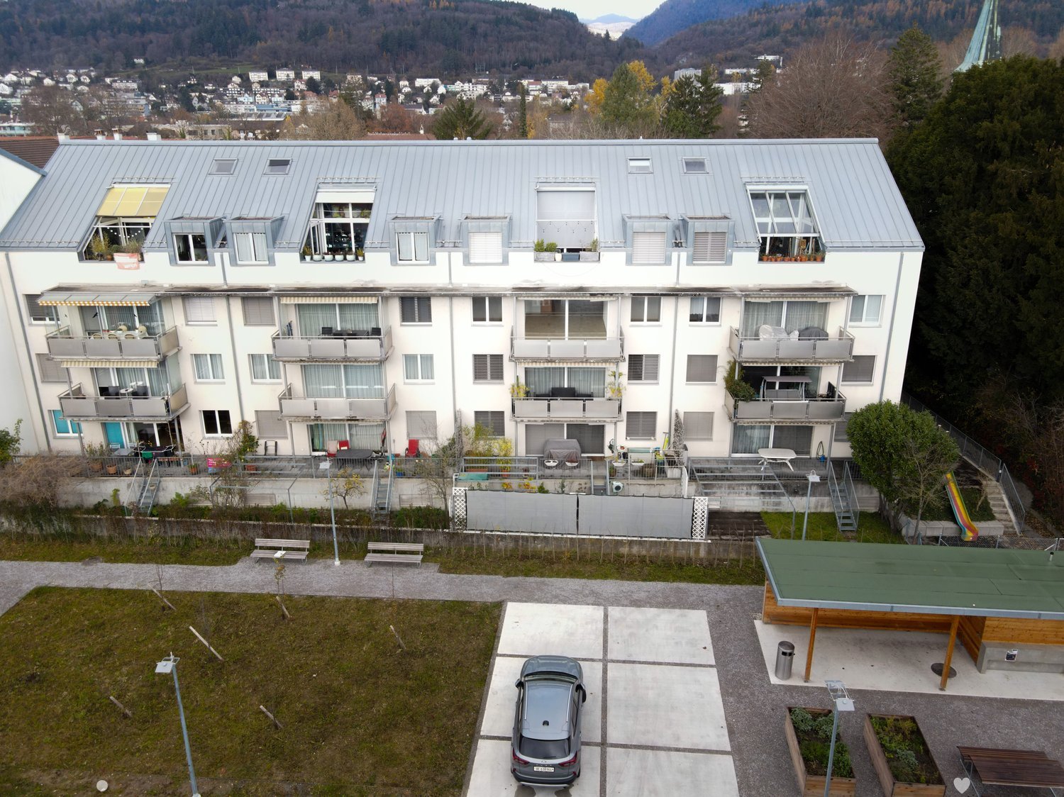 modern apartment building, balcony on every floor, multiple parking spots, green roof