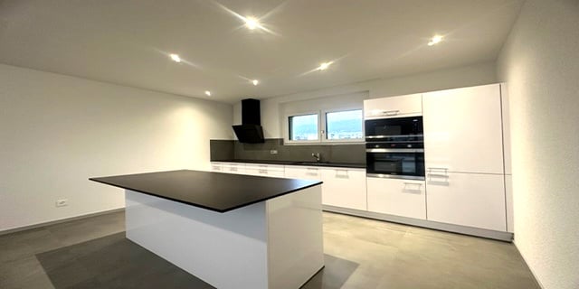 central island, black countertop, white cabinets, built-in appliances, sink, modern design