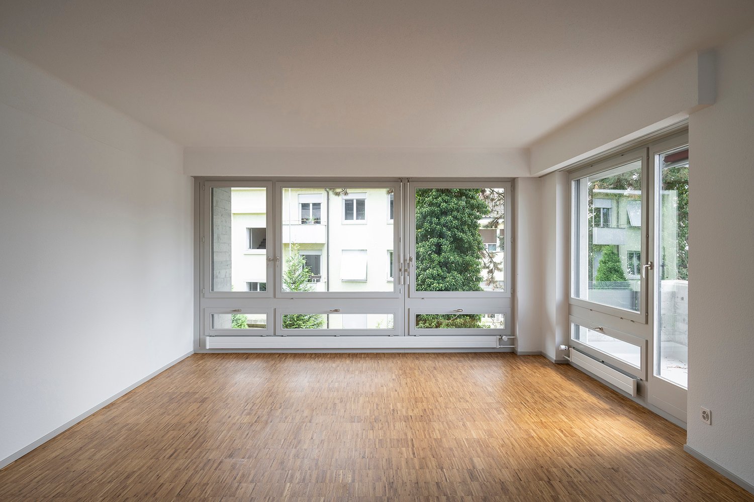empty room, wooden floor, large windows, balcony, white walls, white ceiling