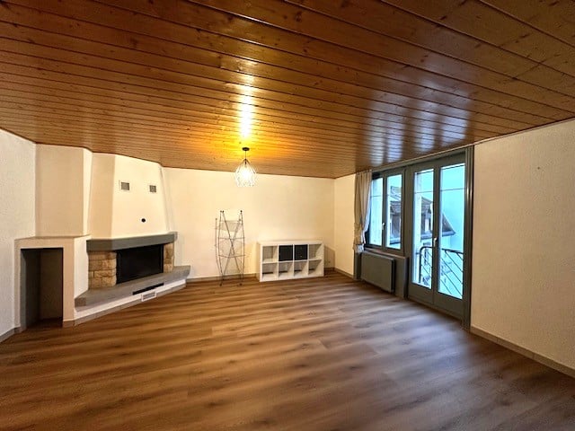 wooden floor, ceiling, white walls, fireplace, large windows, sliding door
