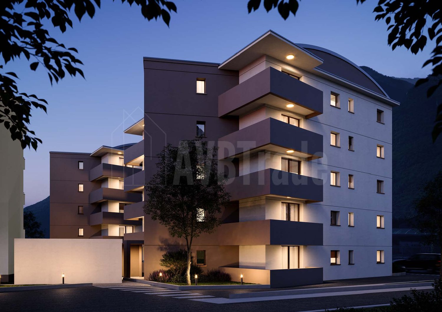 Multi-story apartment building with modern, angular design featuring balconies and terraces, outdoor lighting, and a parking area in the foreground
