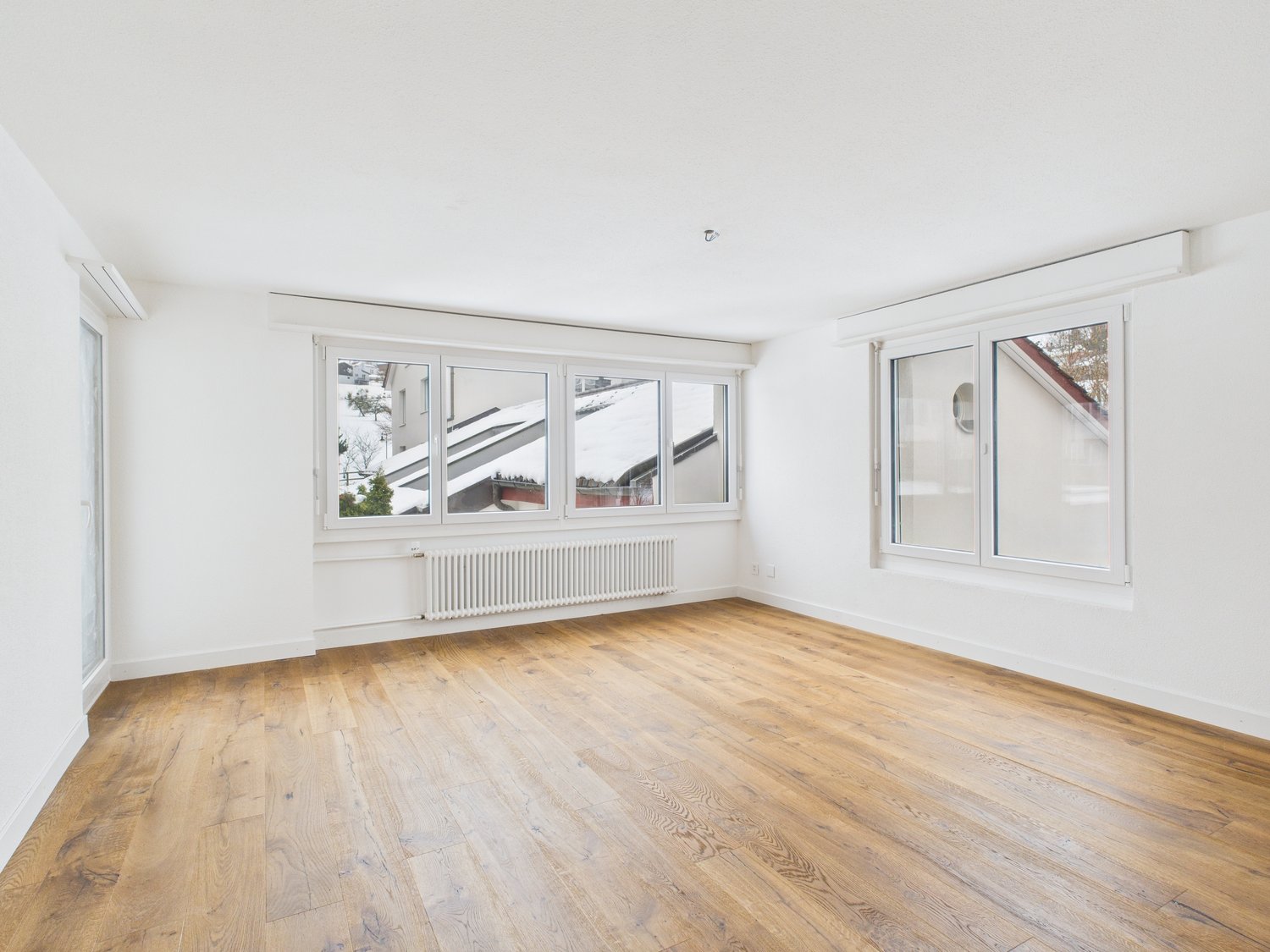 empty room, hardwood floors, white walls, large windows, radiator
