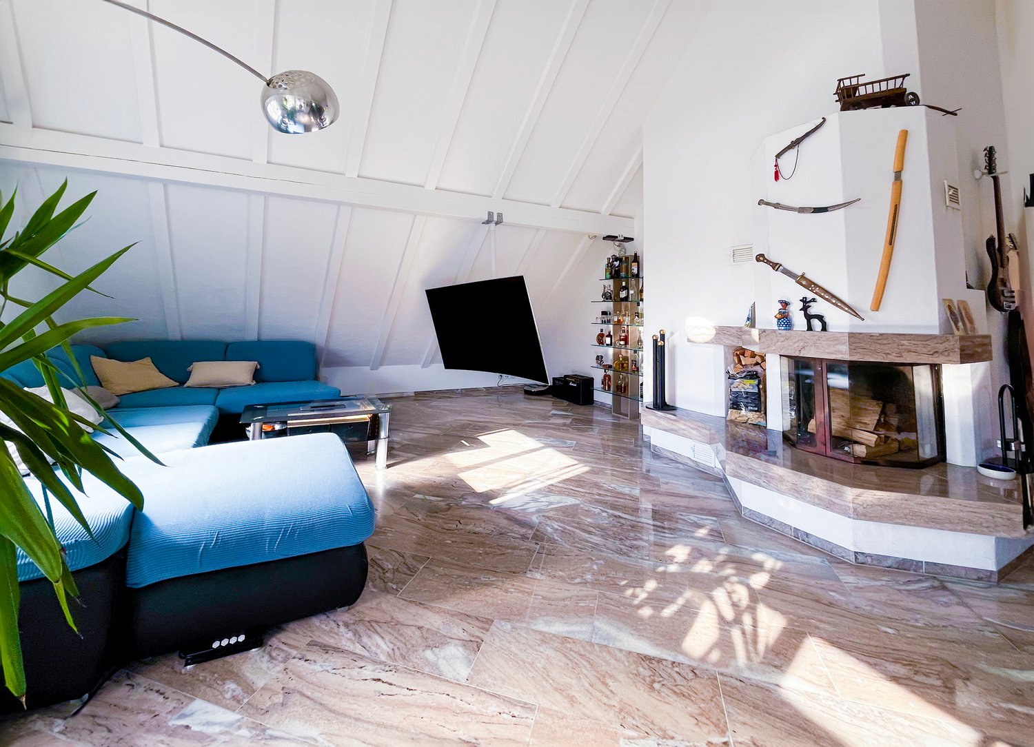 living room with fireplace, blue sofa, coffee table, TV, floor lamp, wooden floor