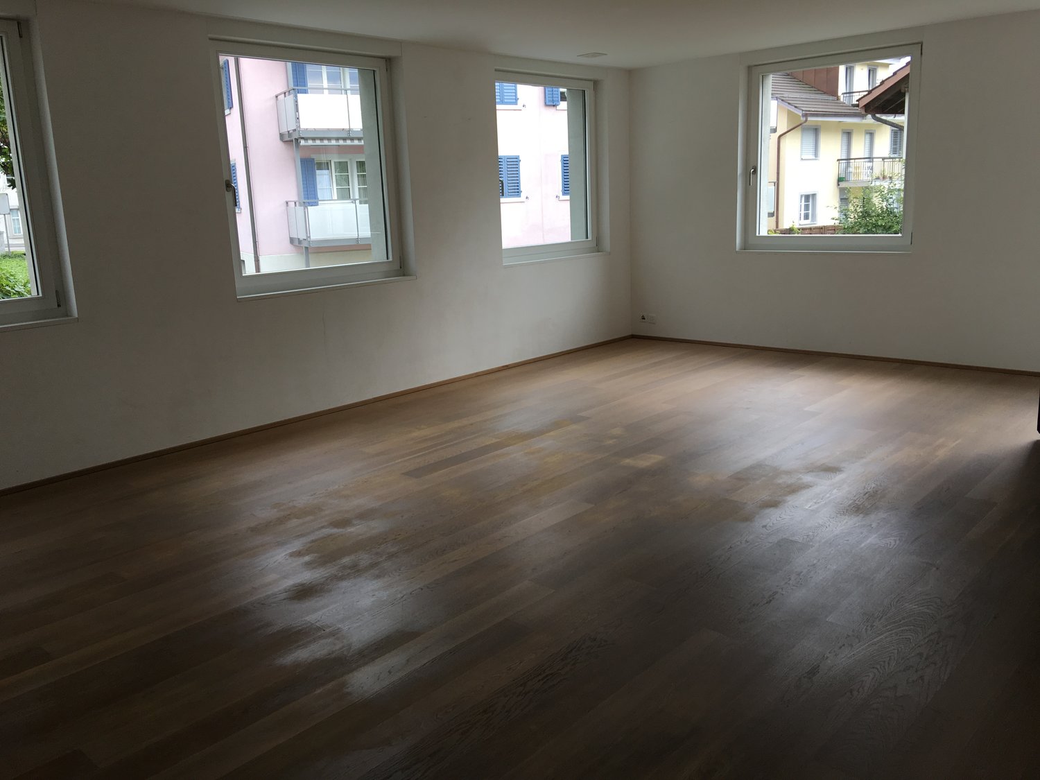 empty room, wooden floor, white walls, three windows, balcony outside