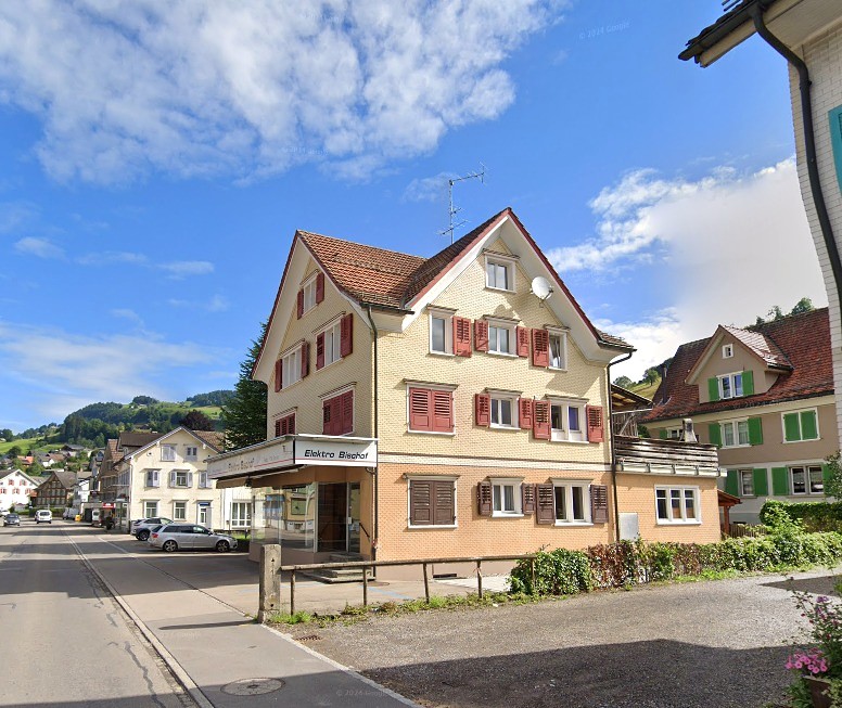 Corner property with commercial area on ground floor and residential area on upper floors, red roof, red shutters, street view