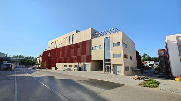 Building with multiple floors, white and red exterior, large windows, garage, street facing