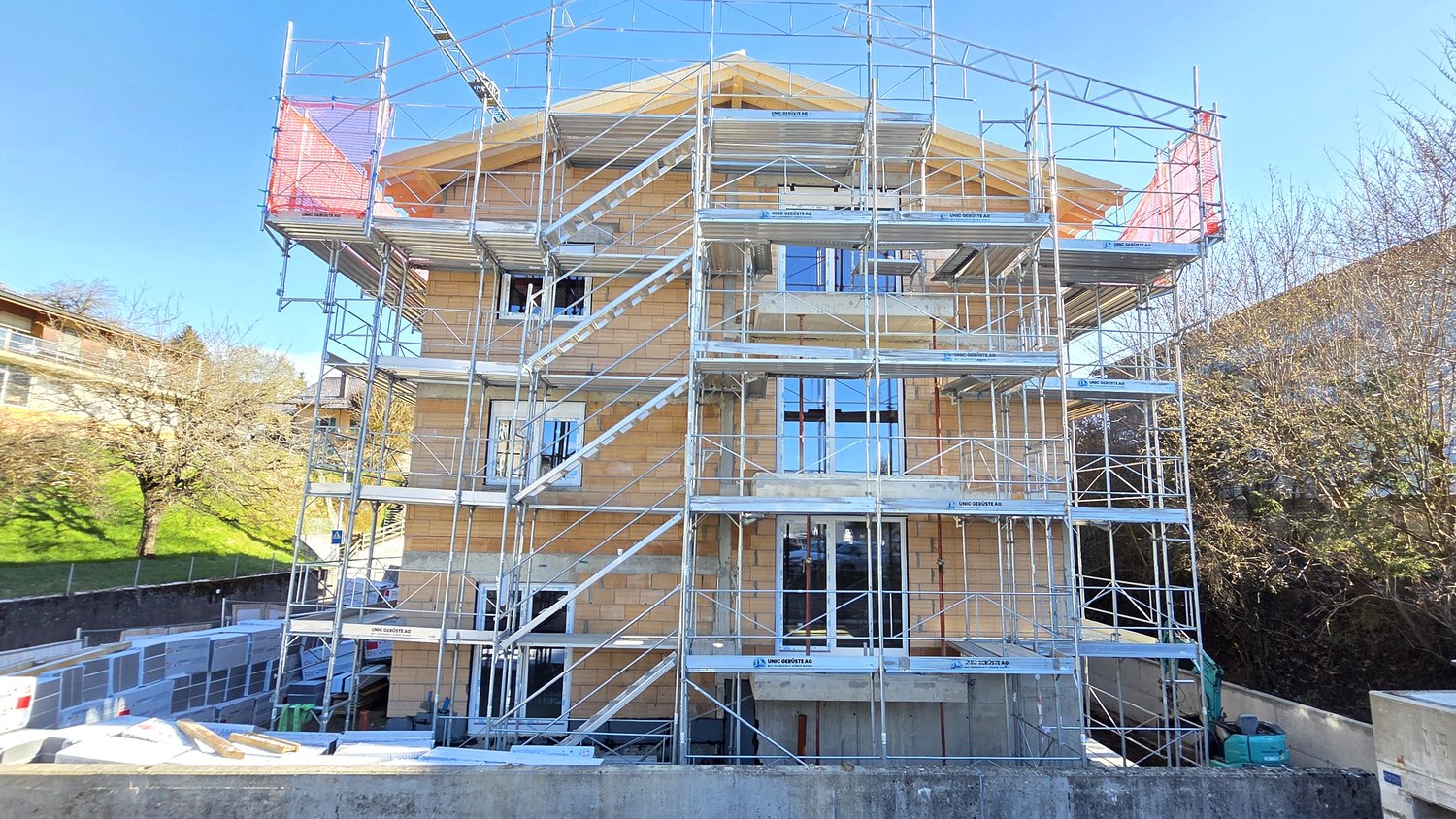 House under construction, brick walls, glass windows, scaffolding, multiple floors