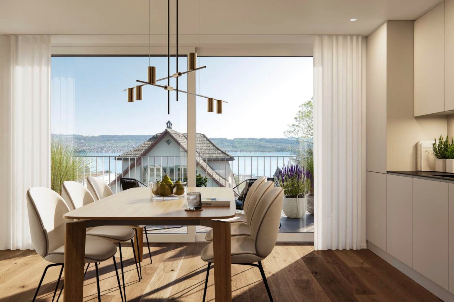 Spacious dining area with a large wooden dining table and beige upholstered chairs. The room features floor-to-ceiling windows with a scenic view of a lake and hills in the distance. The room is illuminated by a modern chandelier with multiple pendant lig