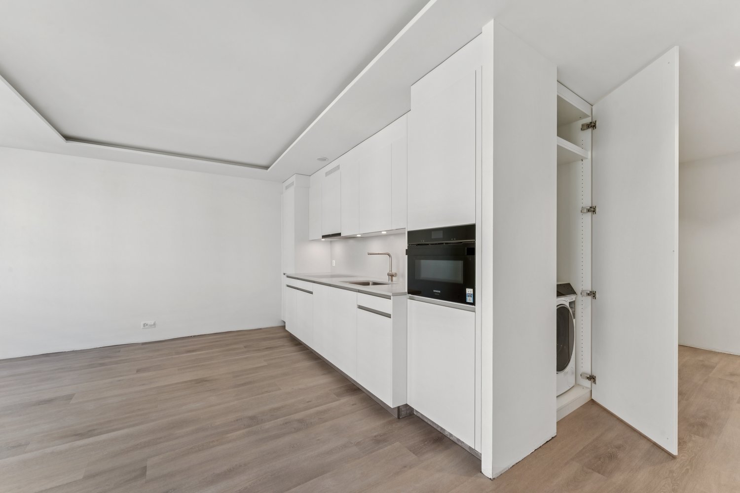 modern, fully equipped kitchen, white cabinets, wooden floors, integrated appliances