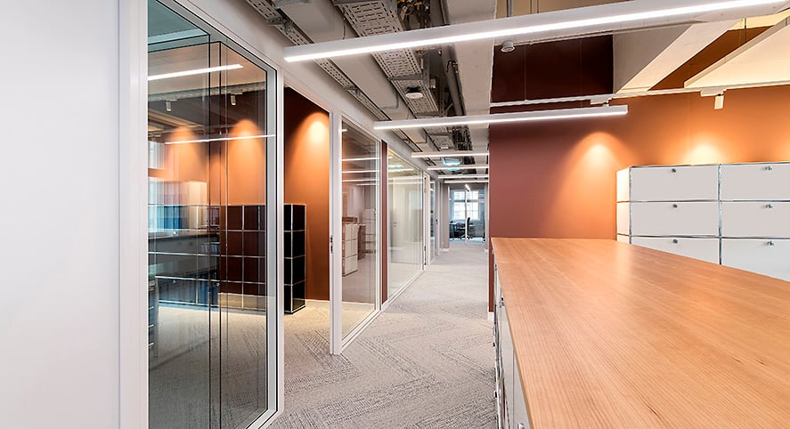 modern office, glass walls, wooden desk, white cabinets, carpeted floor