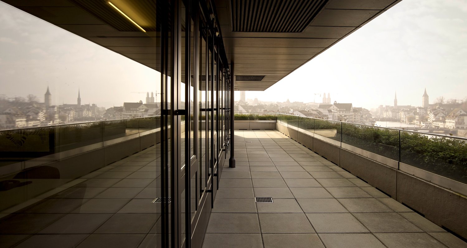 Balcony with glass railings, tiled floor, city view