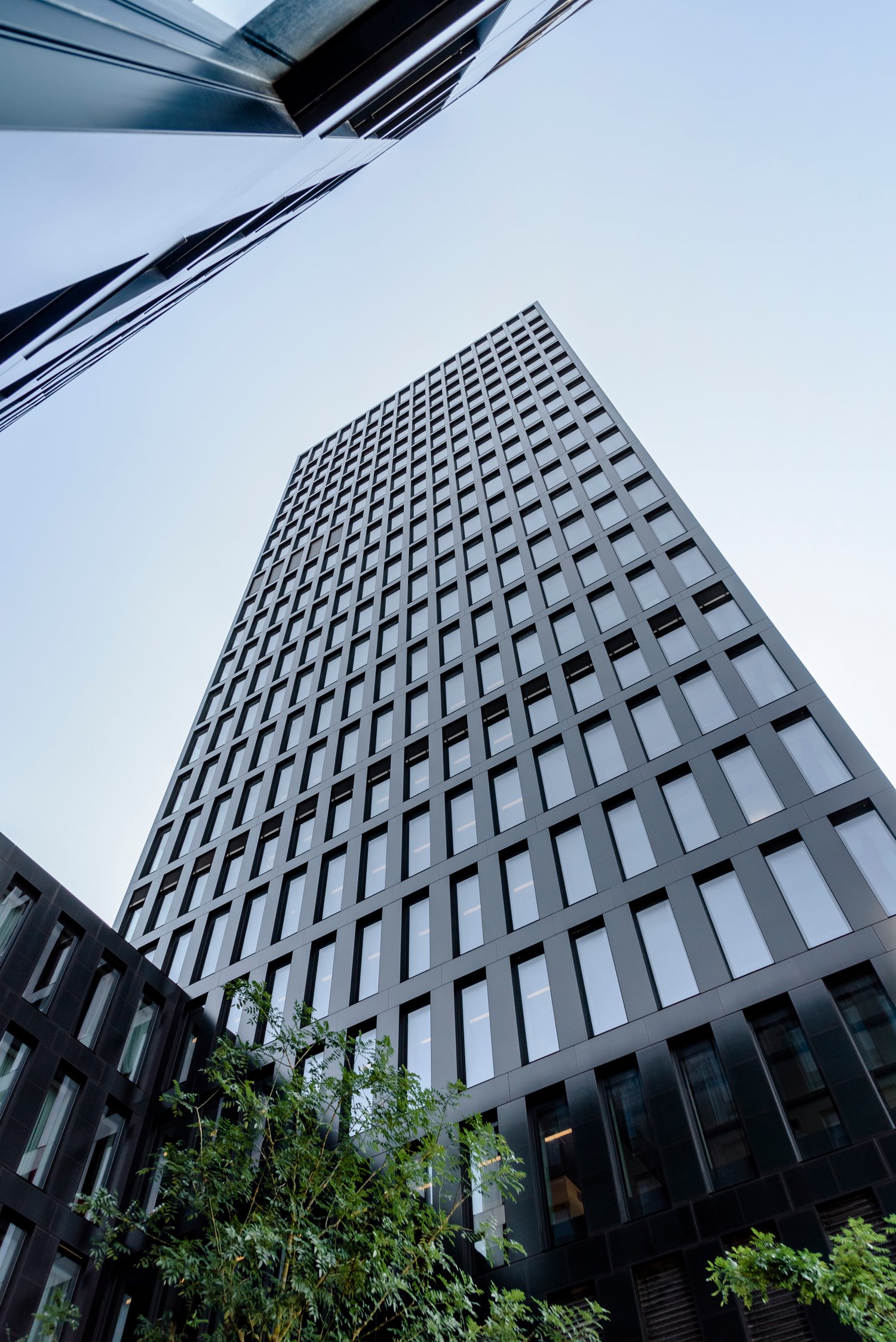 Skyscraper made of black material, many windows, modern design, urban setting