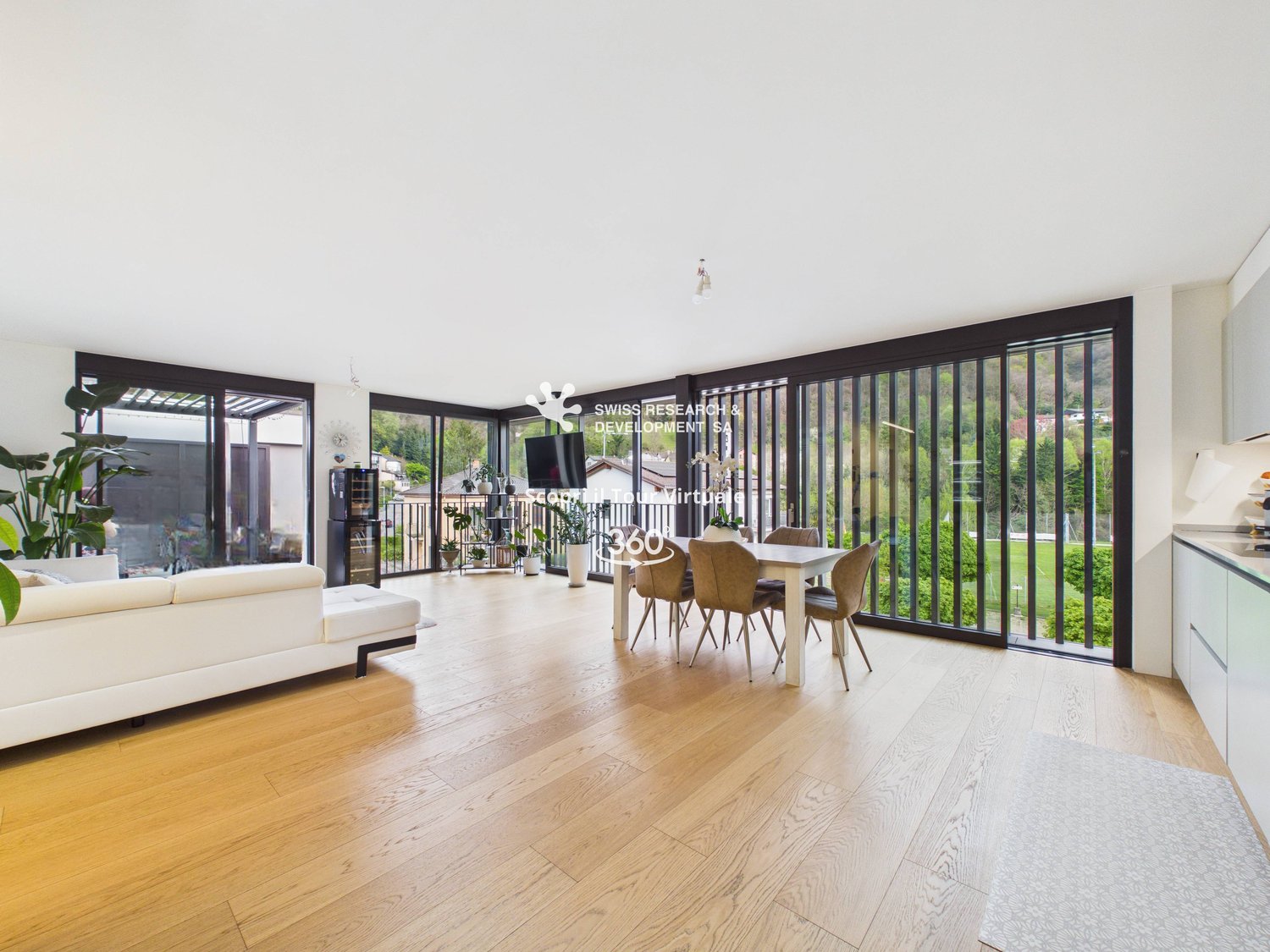 open plan living room and dining area, large windows, balcony, wooden floor, white couch, dining table, kitchen