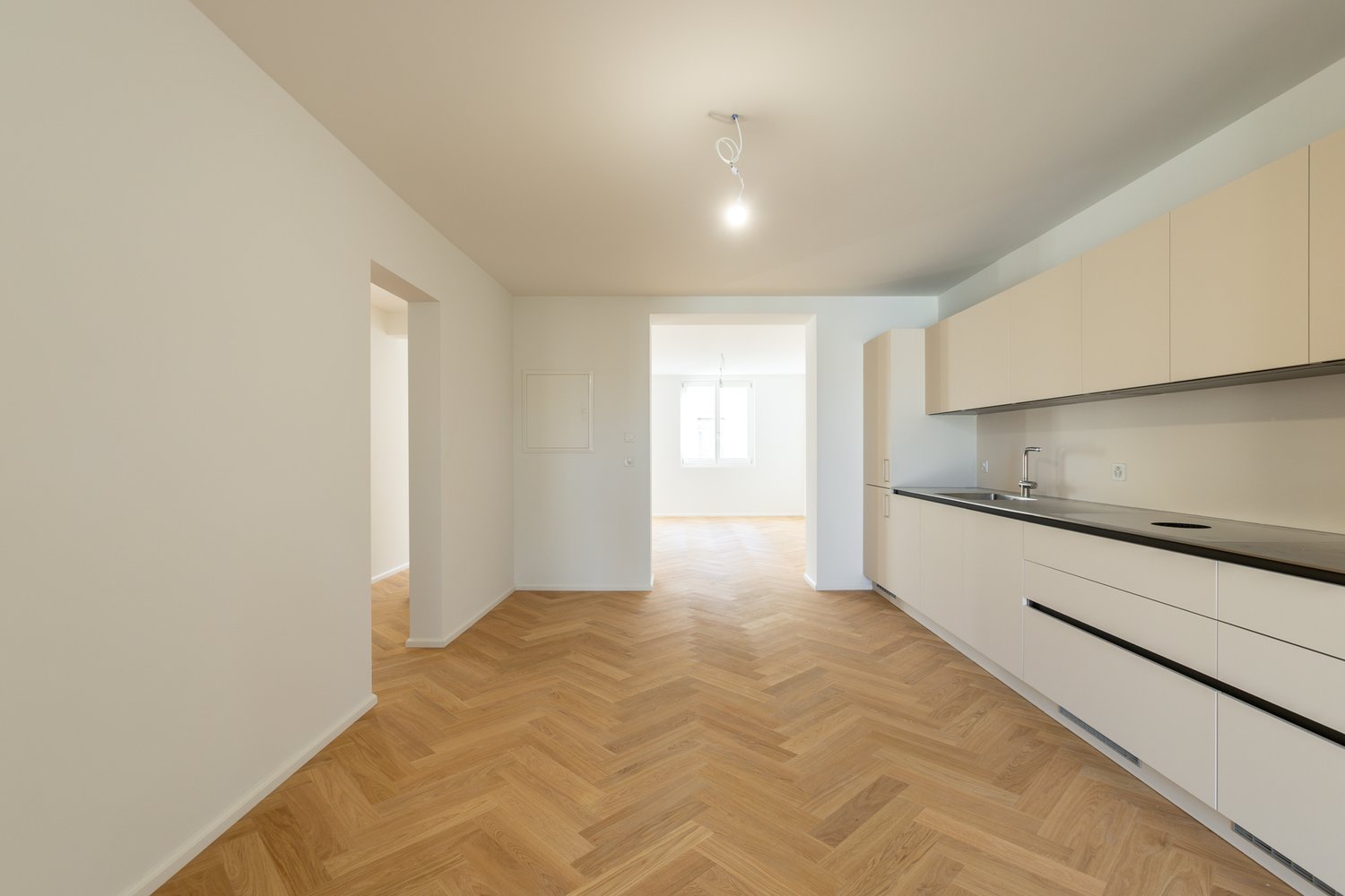 kitchen, wooden flooring, white walls, cabinets, countertop, sink with faucet