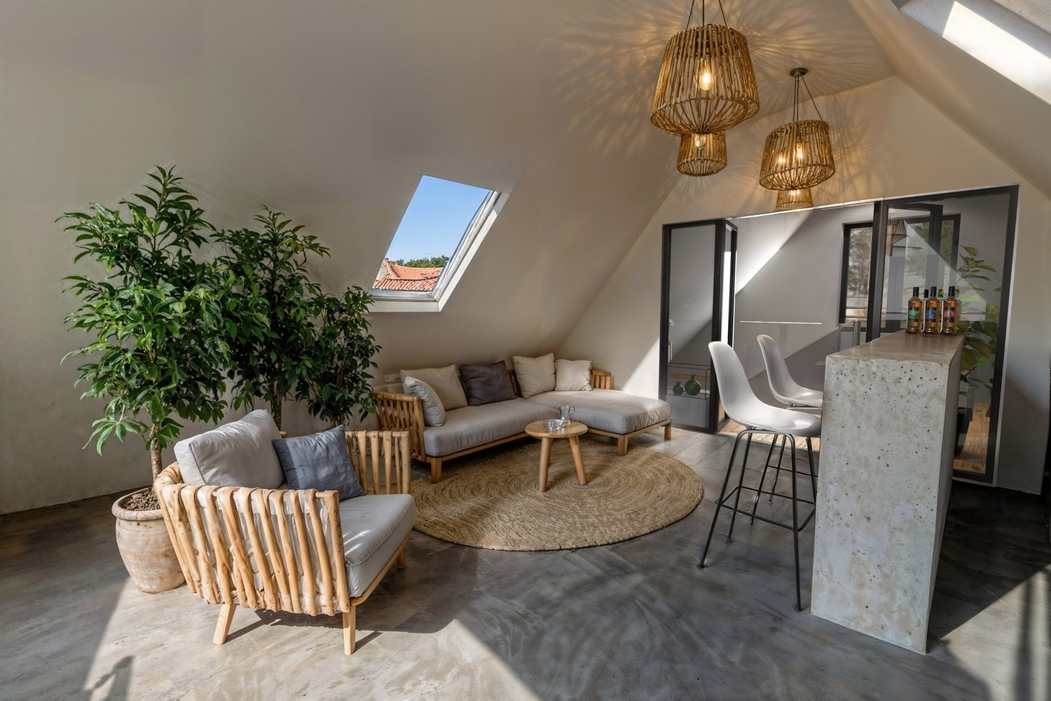 attic room with skylight, sofa, chairs, rug, table, potted plants, wooden furniture