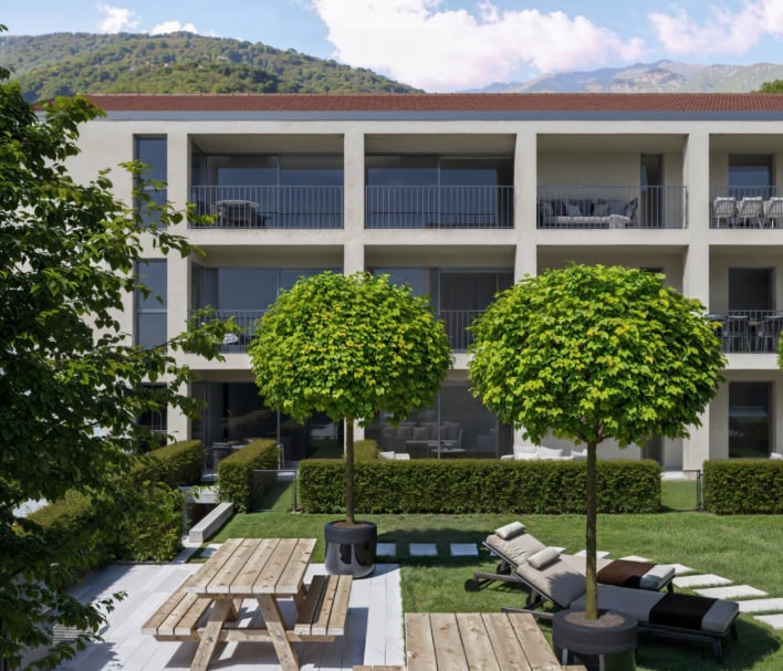 modern building with balconies, landscaped garden, wooden benches, picnic table, loungers