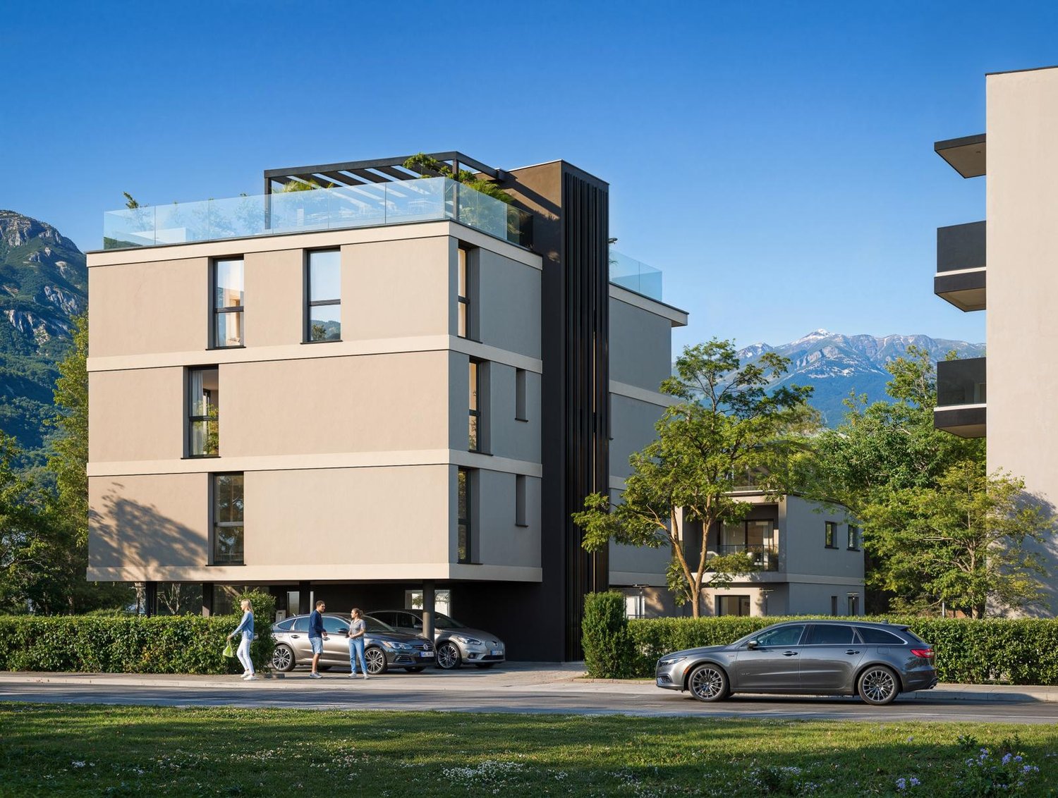 Modern multi-story building with a glass-enclosed terrace on the top floor, surrounded by greenery and mountains in the background.
