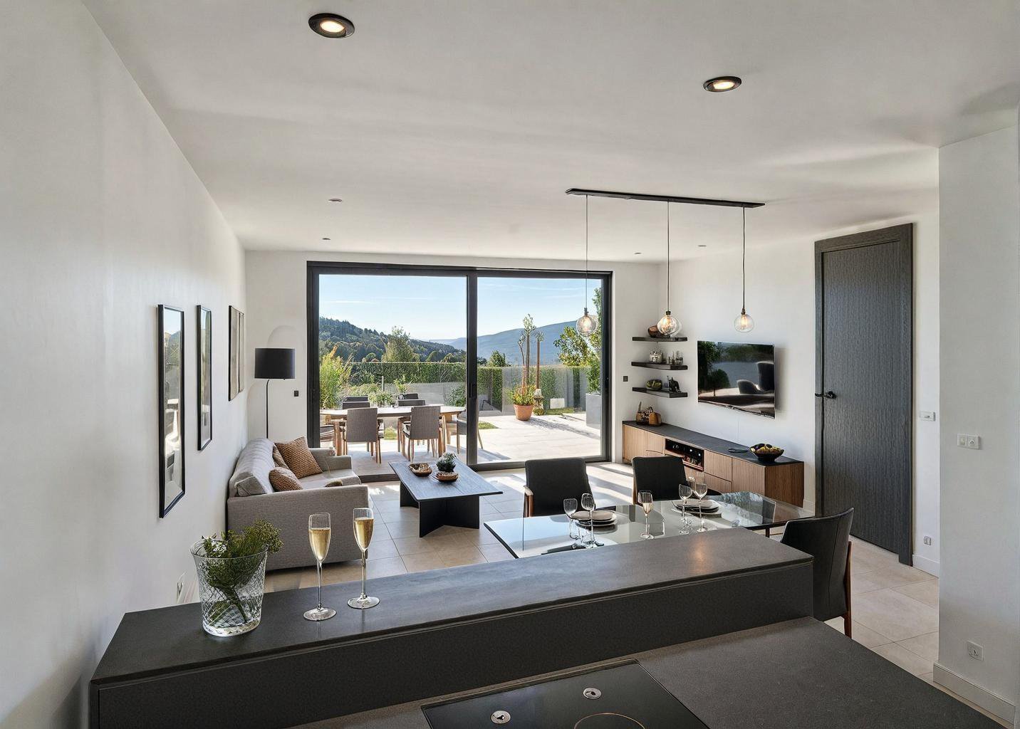 open space with living and dining area, large windows, grey sofa, coffee table, TV