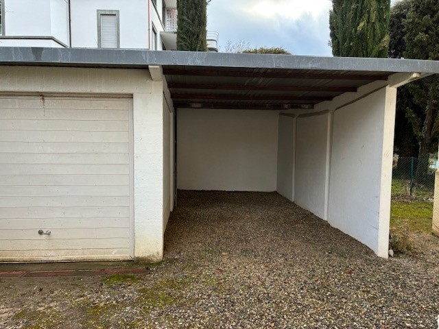 Empty garage with gravel floor and metal roofing