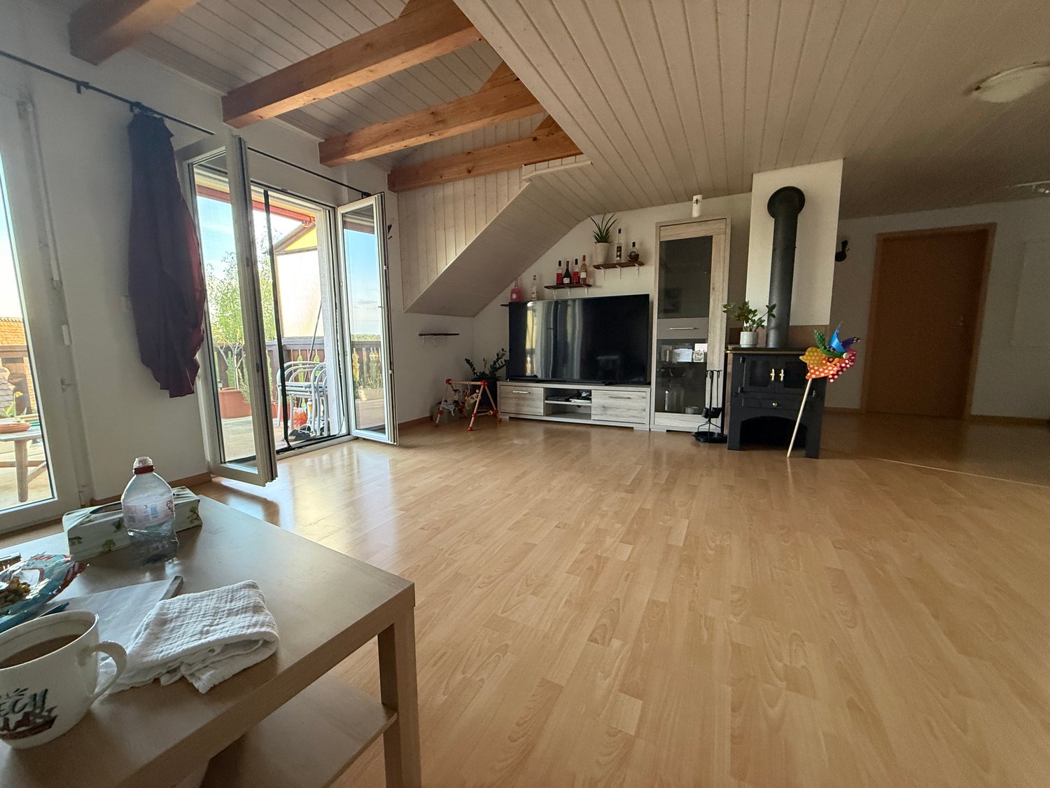 wooden floor, large windows, balcony, TV, wooden beams, fireplace