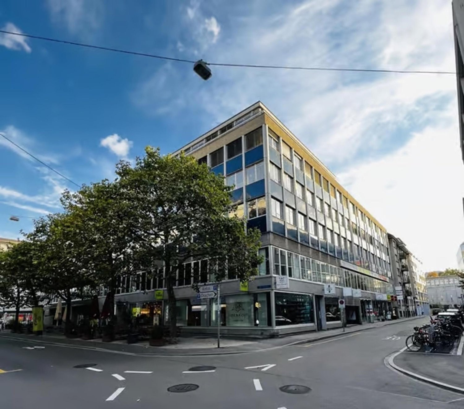 5 story commercial building, glass windows, awnings, bicycles parked in front