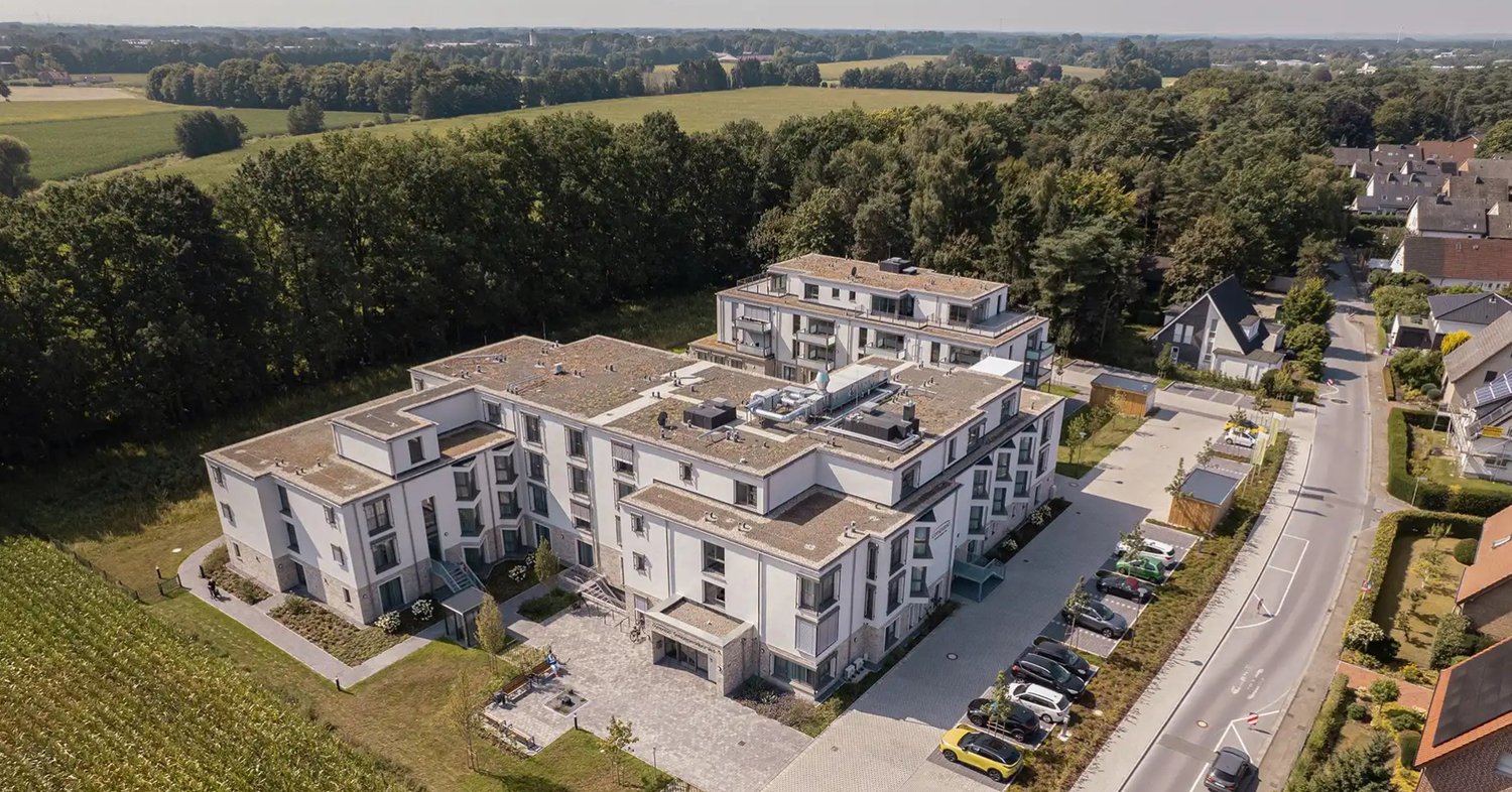 2 story apartment building, white exterior, multiple windows, parking lot, multiple cars parked