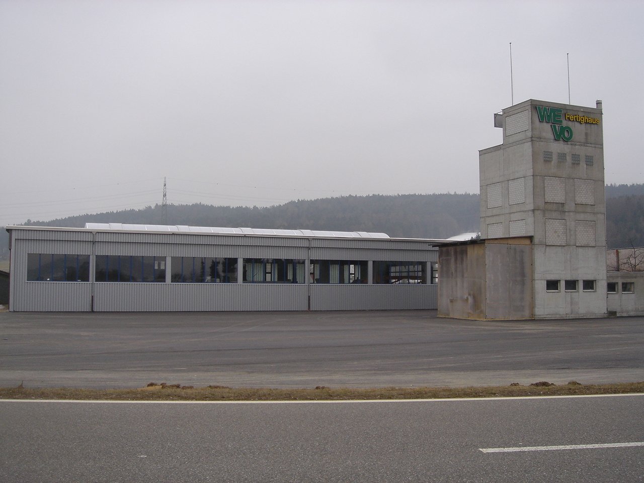 large industrial building, tower, open space, large windows, cloudy sky