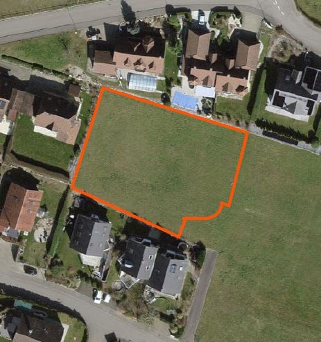 Plot of land with an area of 1,000 square meters, surrounded by houses and greenery.