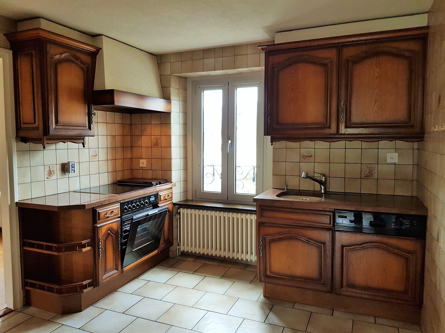 Open kitchen with tile floors, white and brown cabinets, electric oven, dishwasher, gas stove, and wooden countertop