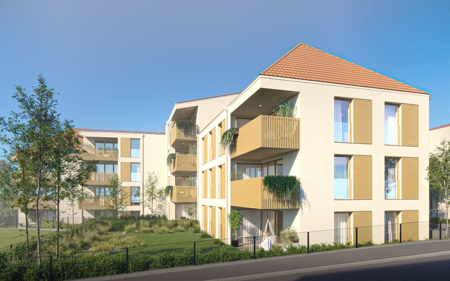 3 story apartment building, beige walls, brown roof, solar panels, multiple balconies, greenery in front