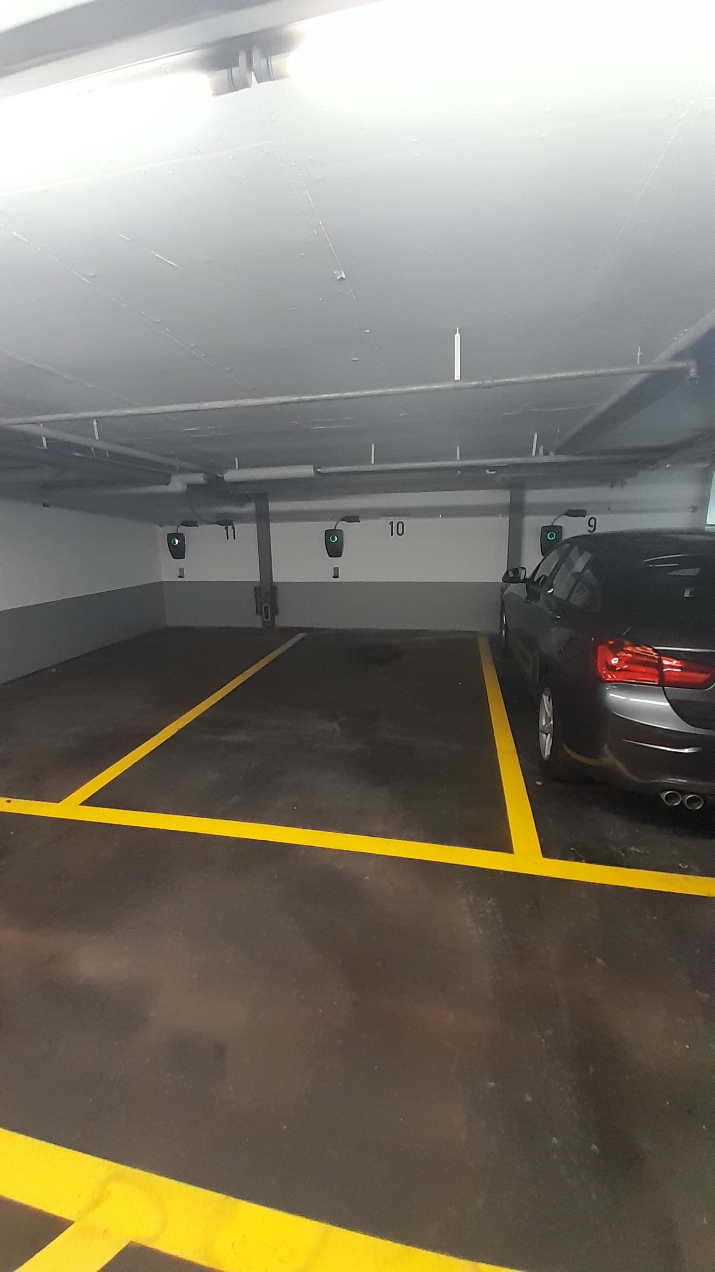 underground parking lot, yellow parking lines, car parked in spot 10